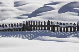 fence submerged in snow 