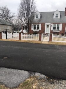 white and brick fence in front of brick home