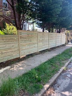horizontal plank privacy fence along sidewalk